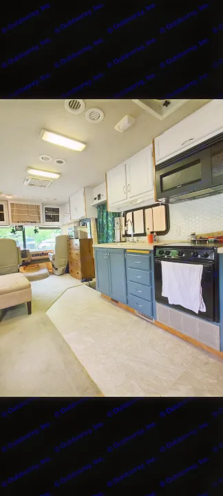 An RV rental's inviting interior features a modern kitchen with blue cabinetry, tile floors, and a comfy carpeted lounge.. Fleetwood Other 2006