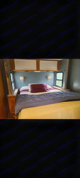 Cozy RV rental bedroom with a neatly made bed in yellow and purple, wall-mounted lamps, and overhead storage.. Fleetwood Other 2006