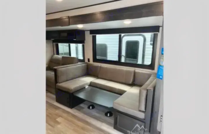 Comfortable U-shaped dinette in this RV rental, with a table and large windows, offering a great space for meals and relaxation.. Jayco Jay Flight 2022