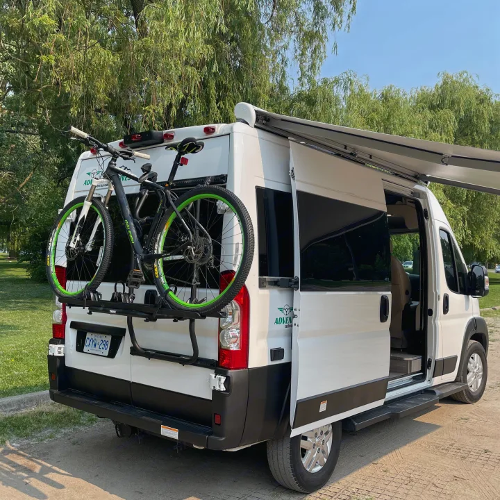 This white RV rental camper van by 'Adventure' is equipped with a bike rack and extended awning for outdoor trips.. Thor Motor Coach Scope 2022