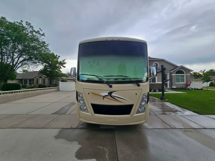 This beige RV rental, parked on a wet driveway, is ready for your next road trip adventure!. Thor Freedom Traveler 2020