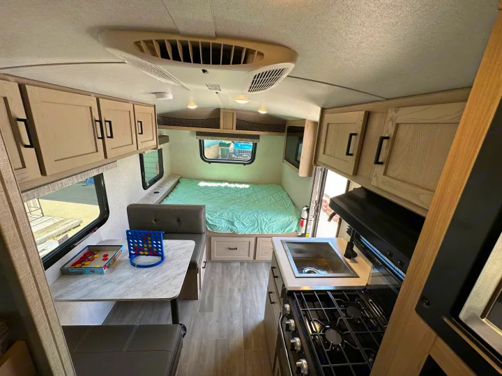 Explore this compact RV rental interior, showcasing a practical kitchen, bed, and convertible dinette. Ready for travel!. Forest River Flagstaff E-Pro 2023