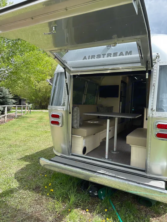 Open Airstream RV rental reveals a cozy interior dinette and living space for camping or travel adventures.. Airstream Flying Cloud 2022