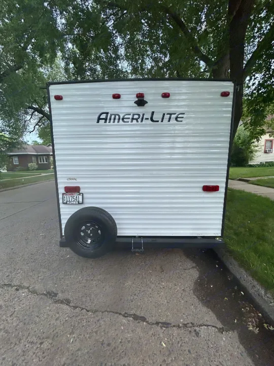 Ameri-Lite RV rental's rear, parked on asphalt. Spare tire visible, ready for travel & outdoor adventures.. Gulf Stream Ameri-Lite Super Lite 2021