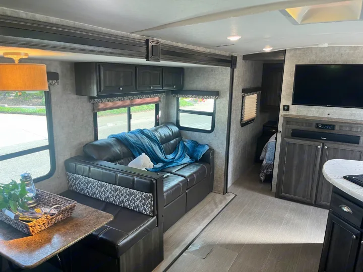 Spacious RV rental interior with modern living and dining areas, entertainment, and full amenities for a comfortable journey.. Highland Ridge RV Light 2017