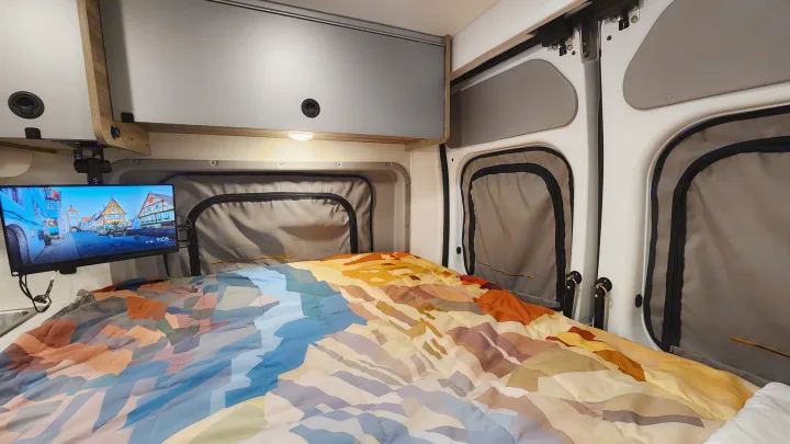 Experience comfort in this RV rental! Features a cozy bed, TV, overhead storage, and insulated windows.. Winnebago Solis 2023