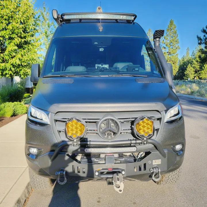 Front of a dark, custom Mercedes Sprinter adventure van with yellow off-road lights, winch, and snorkel. Great for RV rental.. Mercedes-Benz Sprinter 2020