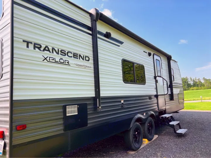 Spacious Transcend XPLOR travel trailer, ideal for an RV rental. Parked in a scenic camp spot with steps out.. Grand Design Transcend Xplor 2020