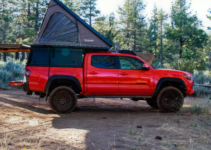 Red Toyota Tacoma with rooftop tent & awning setup for adventure. Perfect for your next overland rv rental trip!. Toyota Tacoma TRD Pro 2023