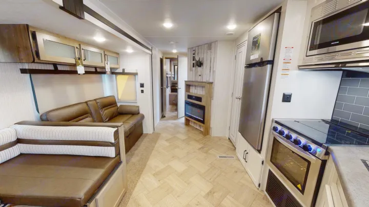 Spacious RV rental interior with living area, kitchen, and fireplace, offering modern amenities for comfortable travel.. Forest River Palomino Puma 2023