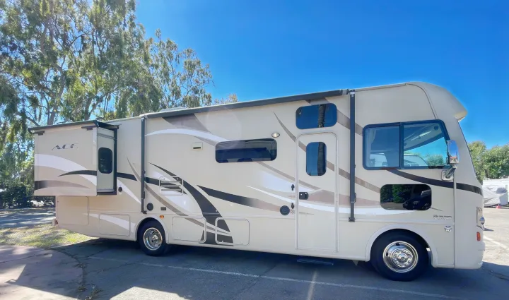 Discover this well-maintained Thor Ace rv rental motorhome, with slide-out and awning, parked outdoors under clear skies.. Thor Motor Coach A.C.E 2017