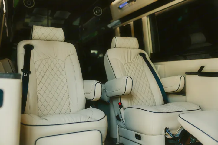 Comfortable cream leather captain's chairs in a spacious RV rental interior. Perfect for road trip luxury.. Ultimate Toys Ultimate Coach 2023