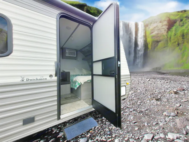 Your next RV rental: a cozy Dutchmen camper by a stunning waterfall on a rocky landscape.. Coleman Lantern 2023