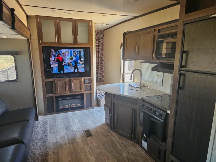 RV rental: modern interior featuring a living area with TV/fireplace and a complete kitchen with appliances.. Crossroads RV Volante 2019