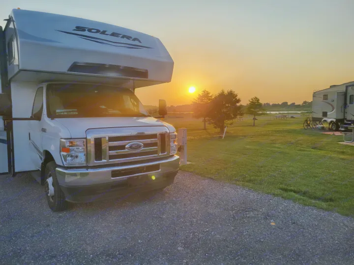 White Solera RV rental parked at campsite 226, bathed in a beautiful sunset glow. Ideal for adventure!. Solera Solera Motorhome 2022
