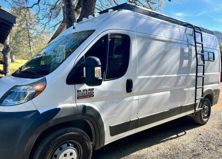 White Ram ProMaster 2500 camper van, ideal for your next rv rental adventure. Features a roof rack and side ladder.. Dodge B Van 2015