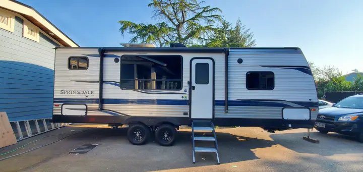 Spacious Springdale travel trailer, perfect for your next RV rental adventure. Side view parked on asphalt.. Keystone RV Springdale 2022
