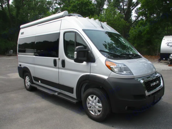 This silver Ram ProMaster camper van is a perfect RV rental, featuring an awning, dark windows, and side steps.. Thor Motor Coach Rize 2023