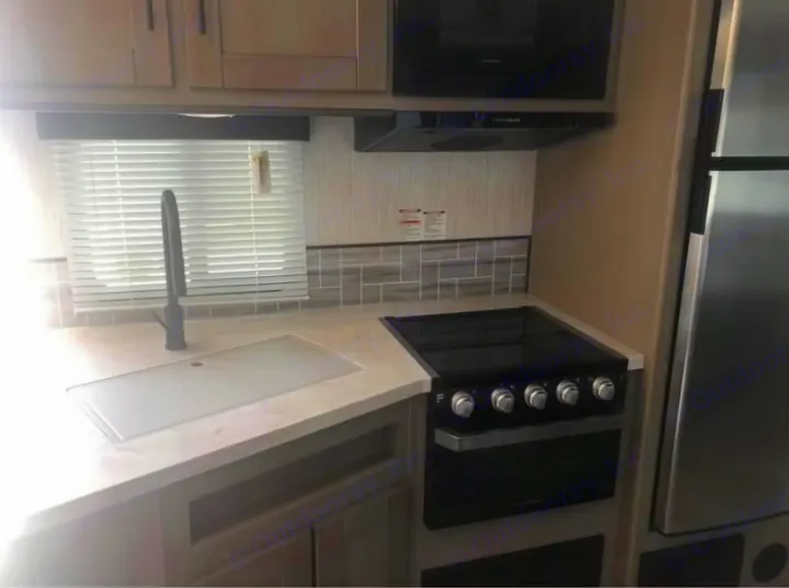 Step inside this RV rental kitchen! Features include a sink with cover, stove, oven, microwave, and fridge. Bright, modern design.. Cruiser Rv Corp Twilight 2021