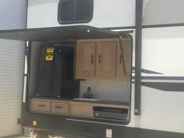 Explore this RV rental's outdoor kitchen, complete with a fridge, sink, cabinets, and grill for convenient camping.. Cruiser Rv Corp Twilight 2021