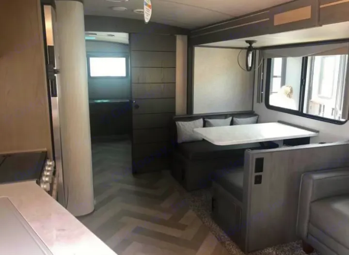 Modern RV rental interior with a dinette, kitchen, and private bedroom/bunk area behind a sliding door. Bright and cozy.. Cruiser Rv Corp Twilight 2021
