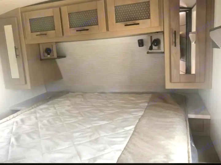 Clean, compact rv rental sleeping area with a quilted bed, overhead cabinets, and small bedside shelves for convenience.. Cruiser Rv Corp Twilight 2021