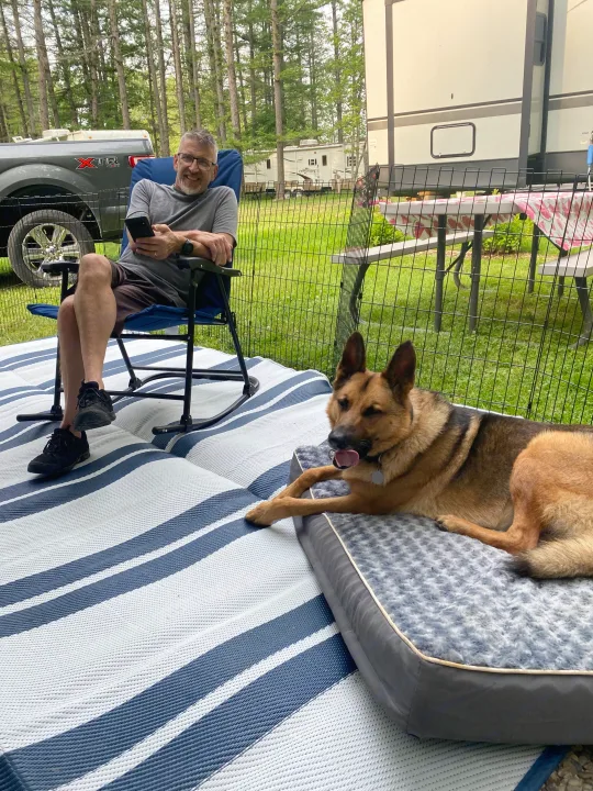 Man and dog relax at their RV rental campsite, enjoying the outdoors.. Jayco Jay Flight SLX 2019
