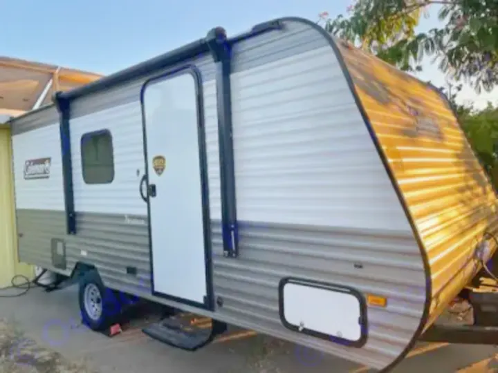 Discover this two-tone (grey & white) travel trailer with an awning, ready for your next RV rental and outdoor journey.. Dutchmen Coleman Lantern LT 2023