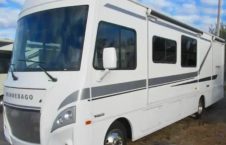 White Winnebago motorhome, an ideal RV rental. Features large windows & an awning for comfortable travel.. Winnebago Intent 2018