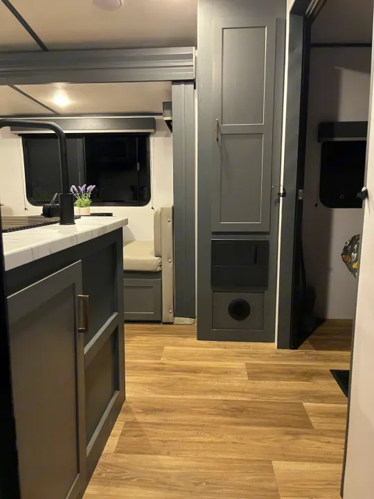 Spacious RV rental interior with a modern kitchen, dinette, and gray storage cabinets on wood-look flooring.. Keystone RV Bullet Ultra Lite 2022