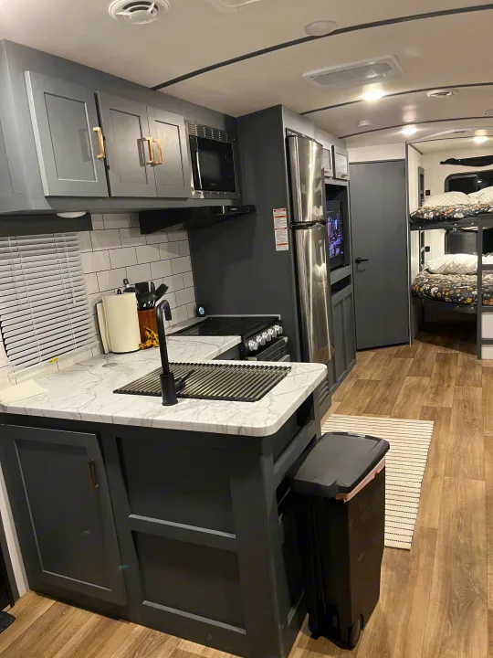 RV rental: sleek kitchen with gray cabinets, marble-look counters, and visible bunk beds for family comfort.. Keystone RV Bullet Ultra Lite 2022