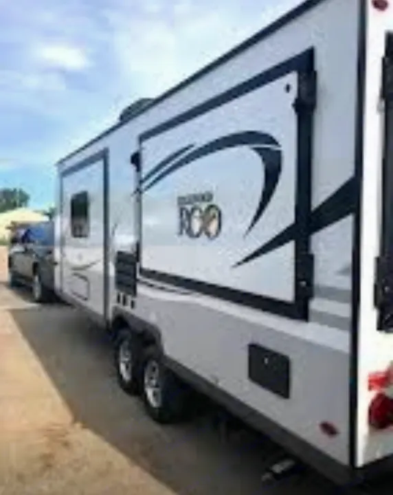 A light-colored Rockwood Roo travel trailer RV, perfect for rv rental, hitched to a dark pickup truck.. Forest River Rockwood Roo 2019