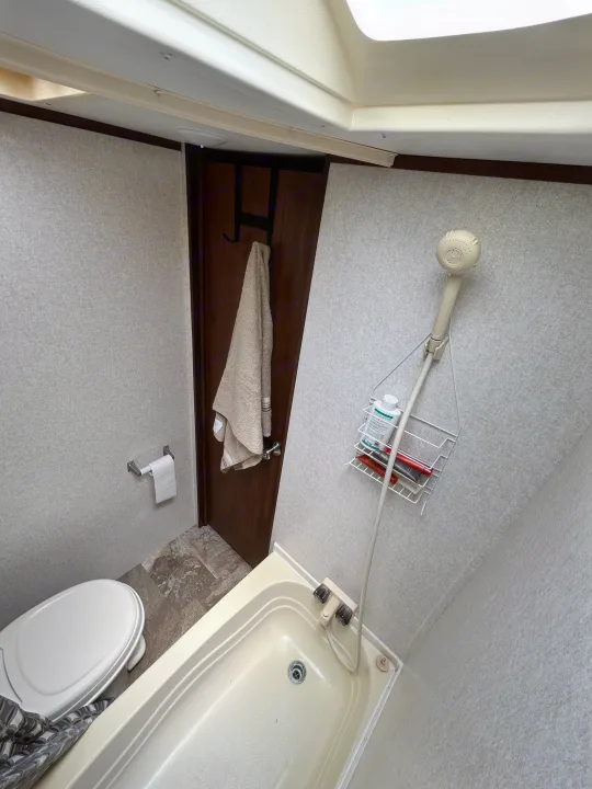 RV rental bathroom: compact design with a toilet, tub/shower, and hanging storage caddy for toiletries.. Jayco Jay Flight SLX 2017
