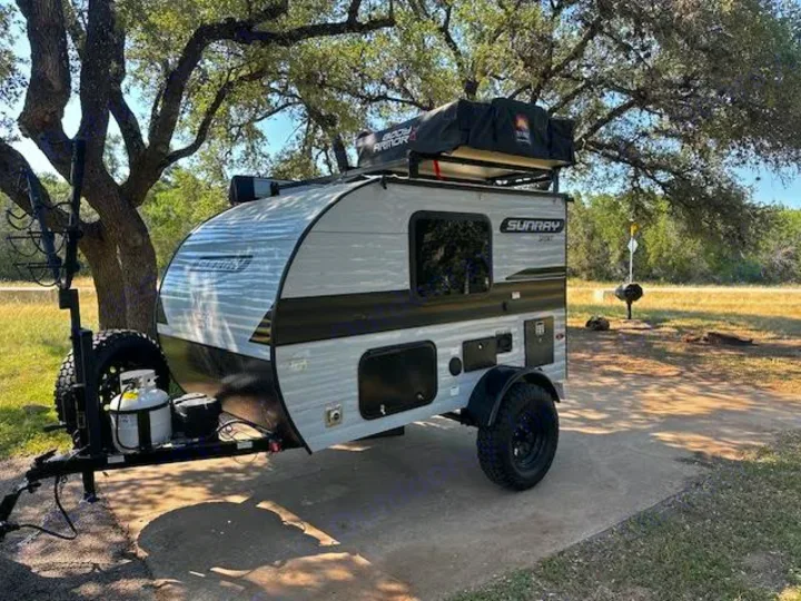 Explore the outdoors with this compact Sunray RV rental, featuring a rooftop tent and rugged tires.. Sunset Park RV SunRay 2023