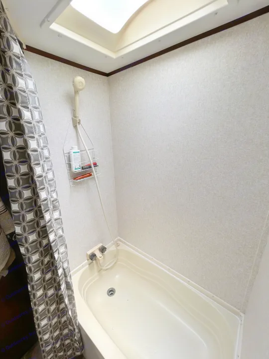 Compact RV rental bathroom with an off-white tub, handheld shower, and ceiling skylight.. Jayco Jay Flight SLX 2017