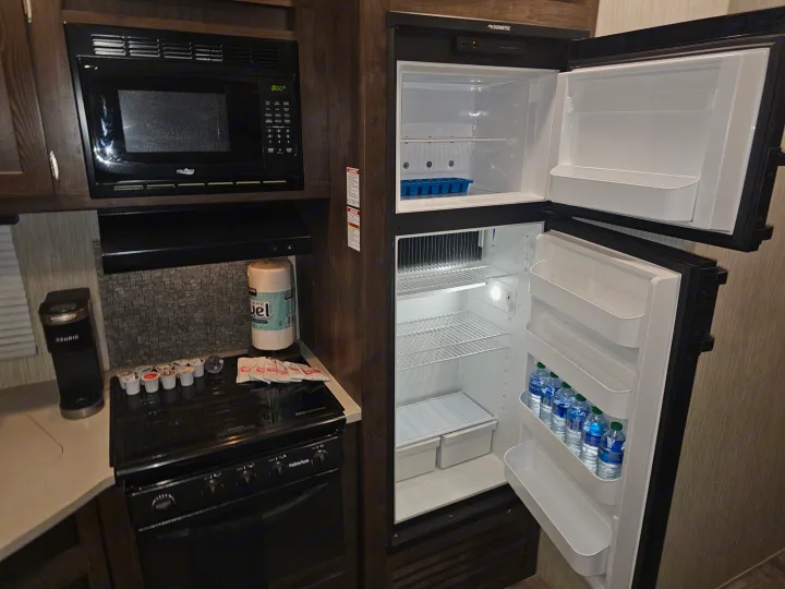 This rv rental kitchen provides a microwave, Keurig coffee maker, Suburban stove, and Dometic refrigerator, all set up.. Crossroads RV Volante 2019