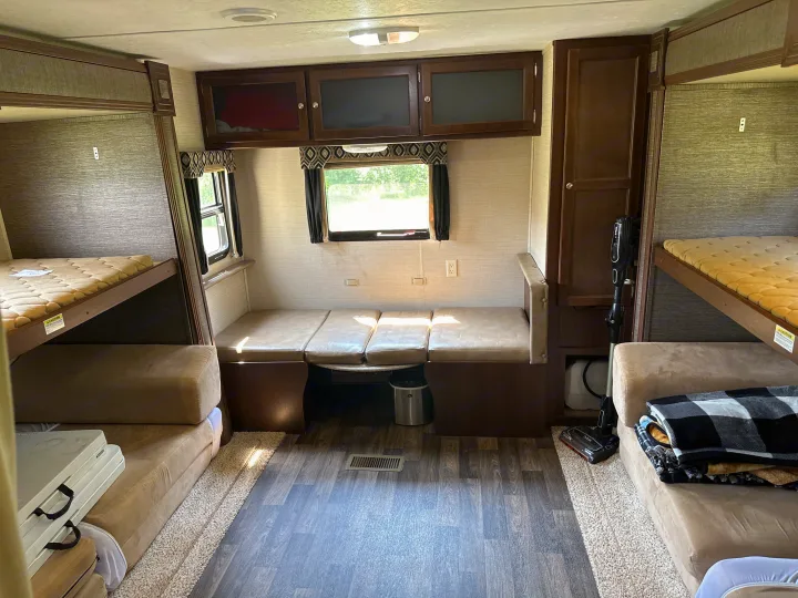 Inside an RV rental: features include four bunk beds, a dinette area, and ample overhead storage for travel comfort.. Keystone RV Bullet Ultra Lite 2015