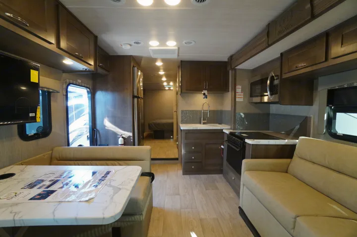 Spacious RV rental interior featuring a full kitchen, comfortable dinette, and sofa. Ideal motorhome living space for travel.. Nexus Triumph 32T 2023