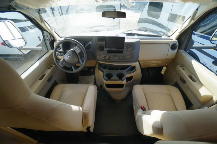 RV rental interior: driver's cockpit with Ford steering wheel, dashboard, and front seats, perfect for a motorhome adventure.. Nexus Triumph 32T 2023