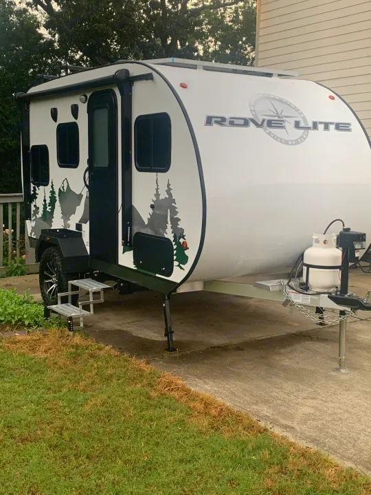 Experience outdoor adventure with this Rove Lite RV rental! A white teardrop travel trailer with cool mountain decals.. Travel Lite Rove 14BH 2024