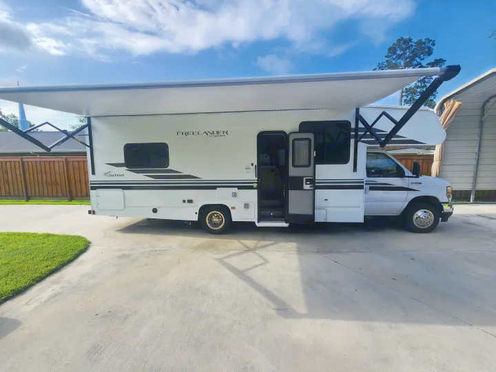 Coachmen Freelander RV rental parked on concrete with awning extended, ready for adventure.. Coachmen Freelander 2023