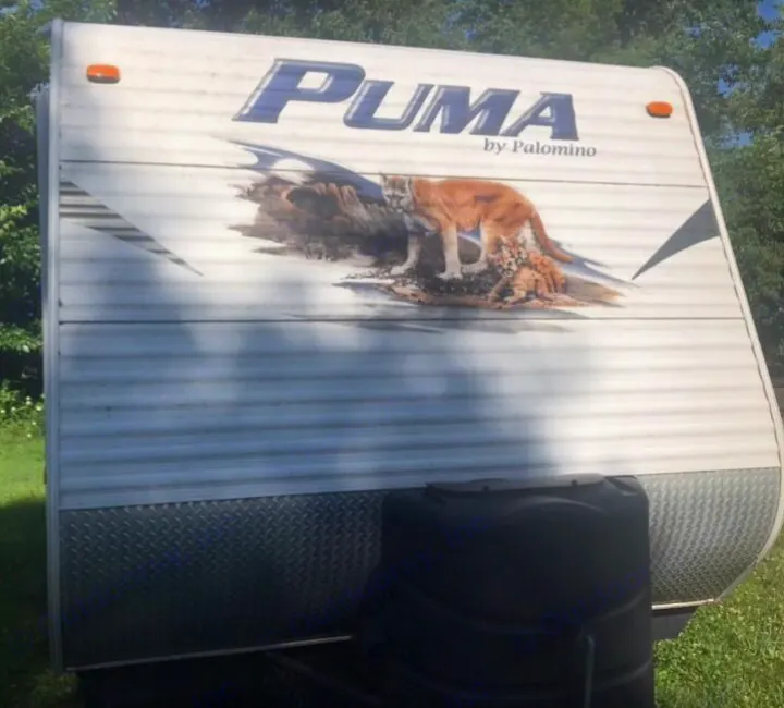 Front of a "Puma by Palomino" travel trailer, an ideal RV rental. Features a cougar and cub graphic.. Forest River Palomino Puma 2009