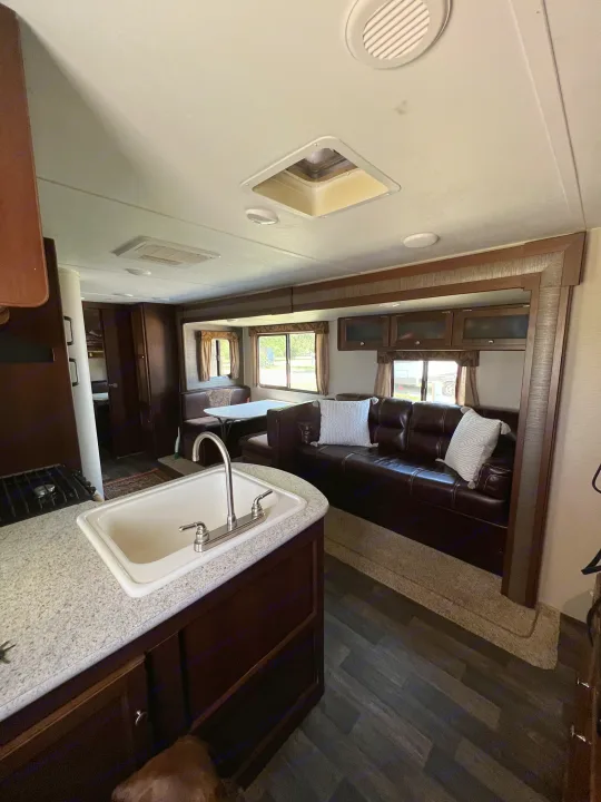 Spacious & clean RV rental interior with kitchen, dining booth, and comfortable sofa, perfect for your next road trip!. Keystone RV Bullet Ultra Lite 2016