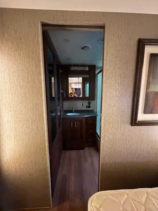 Interior of an RV rental: a well-appointed bathroom with a spacious vanity, mirror, and sink, reflecting the photographer.. Newmar Canyon Star 2016