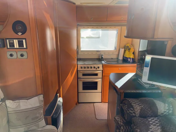 Cozy RV rental interior featuring a compact kitchen, living area, and amenities, perfect for travel comfort.. Fiat Ducato 2005