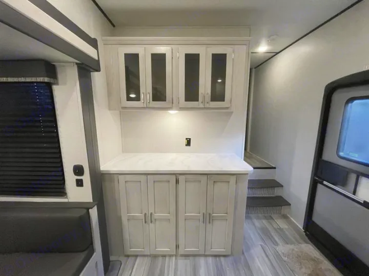 Modern RV rental interior: well-lit cabinets, cozy seating, bunk bed, and access steps. Ready for adventure.. Keystone Sprinter 2022