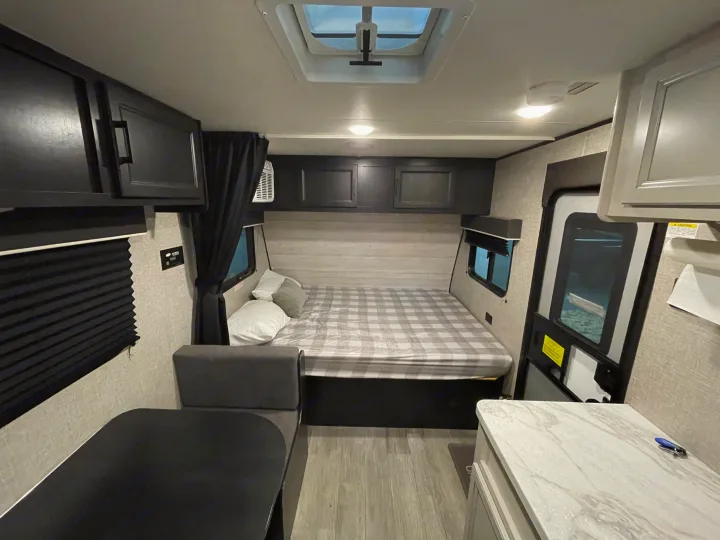 Relax in this RV rental's tan recliner and passenger seat, featuring wood flooring and a safety fire extinguisher.. Jayco Jay Flight SLX 2022