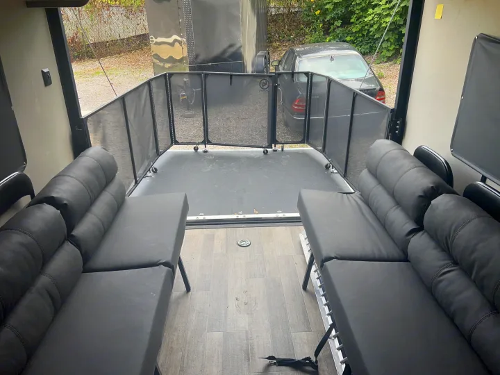Experience a versatile RV rental interior. This toy hauler offers comfortable black seating & durable flooring with a rear ramp.. Coachmen Catalina 2021