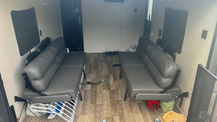 RV rental: Spacious toy hauler interior with two convertible sofas, wood-look floor, and integrated cargo tie-downs.. Coachmen Catalina 2021