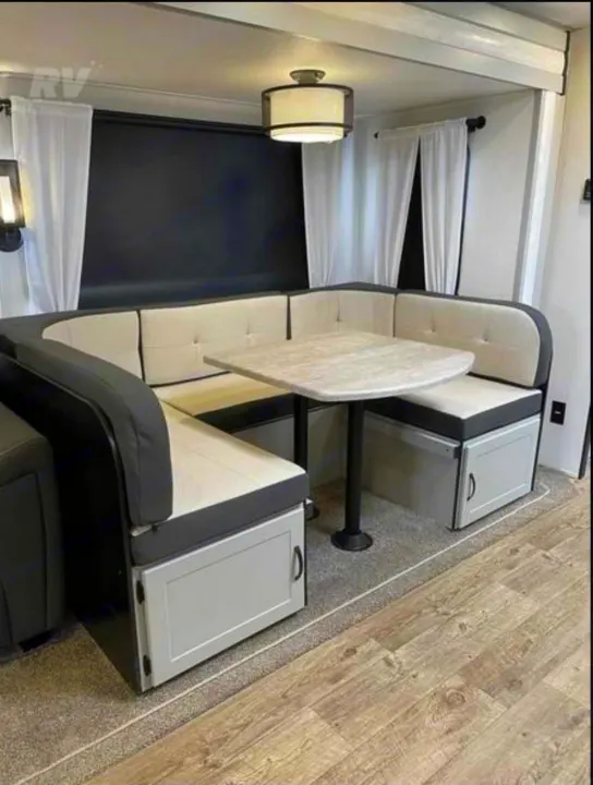 RV rental: Modern dinette area with U-shaped booth seating, a table, and convenient under-seat storage.. Forest River Vibe 2022